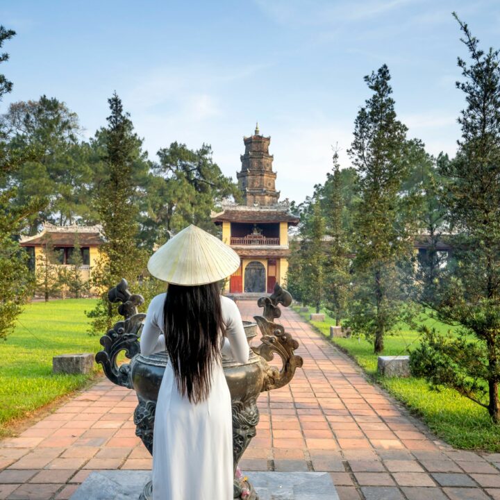 Traditionelle vietnamesische Frau vor einem Tempel