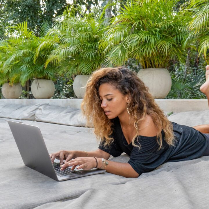 Frau mit lockigen Haaren arbeitet entspannt an ihrem Laptop