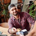 Mann bezahlt mit seiner Kreditkarte