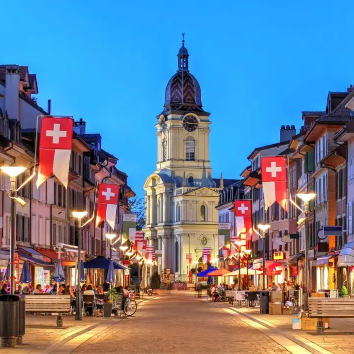 Eine Stadt am Abend als Symbol für Steuern in der Schweiz
