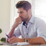 Ein Mann sitzt nachdenklich vor seinem Laptop