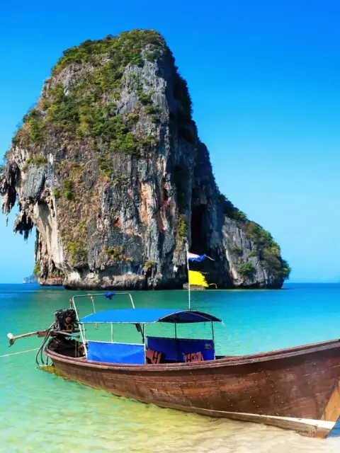 Ein Boot vor einer Insel in Thailand als Symbol für die Krankenversicherung in Thailand