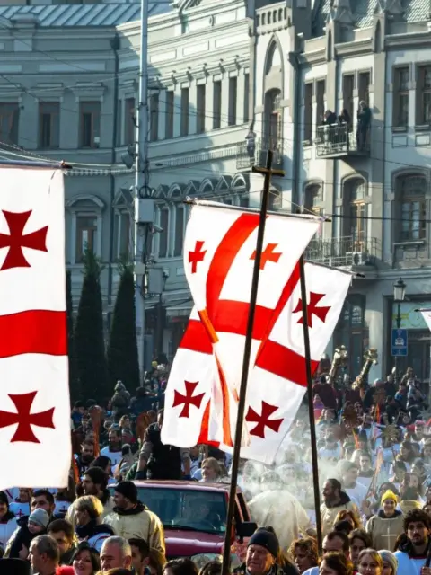 Flaggen auf einem Umzug als Symbol für Leben in Georgien