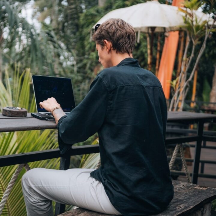 Mann arbeitet im Freien am Laptop