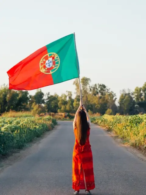 Eine Frau mit einer Flagge als Symbol für Visum Portugal