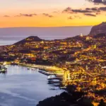 Eine Stadt am Meer bei Abend als Symbol für Bankkonto in Portugal