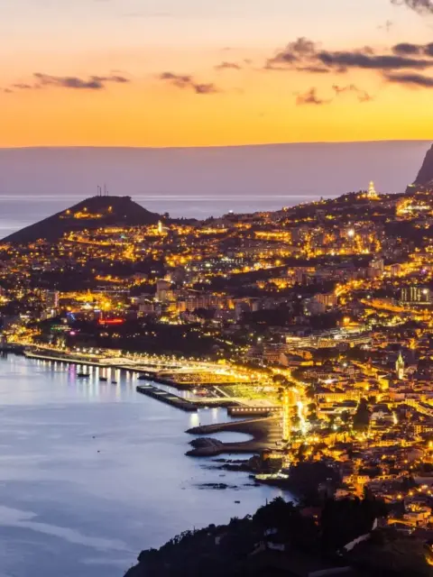 Eine Stadt am Meer bei Abend als Symbol für Bankkonto in Portugal
