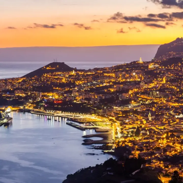 Eine Stadt am Meer bei Abend als Symbol für Bankkonto in Portugal