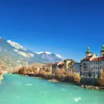 Ein See neben Häusern als Symbol für einen Aufenthalt in Österreich