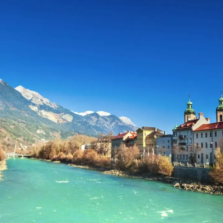 Ein See neben Häusern als Symbol für einen Aufenthalt in Österreich