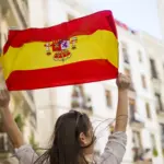 Eine Frau mit einer spanischen Flagge als Symbol für Steuern in Spanien