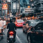 Mann auf Motorrad in Bangkok unterwegs um ein Bankkonto in Thailand zu eröffnen.