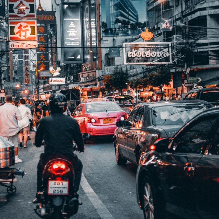 Mann auf Motorrad in Bangkok unterwegs um ein Bankkonto in Thailand zu eröffnen.
