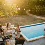 Freunde am Pool als Symbol für Lebensmittelpunkt und Wohnsitz trennen