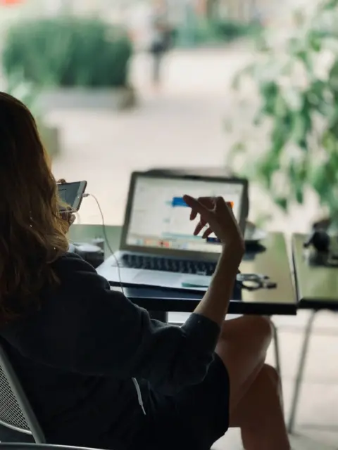 Eine Frau am Laptop als Symbol für Bankkonto ohne Wohnsitz